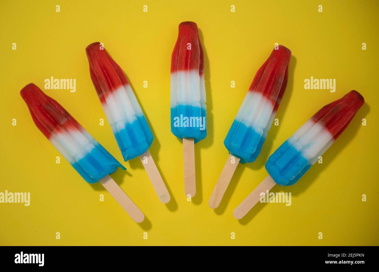 Rot, Weiß und Blau Neuheit Eis Bombpop auf gelbem Hintergrund geschossen, stoppen Action-Animation explodiert wie ein Feuerwerk. Serie 3 von 8. Stockfoto