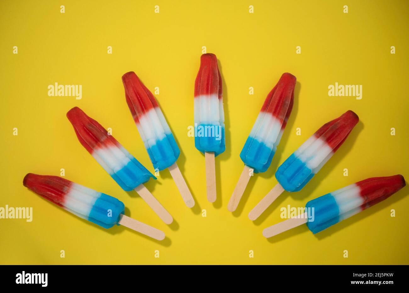 Rot, Weiß und Blau Neuheit Eis Bombpop auf gelbem Hintergrund geschossen, stoppen Action-Animation explodiert wie ein Feuerwerk. Serie 4 von 8. Stockfoto