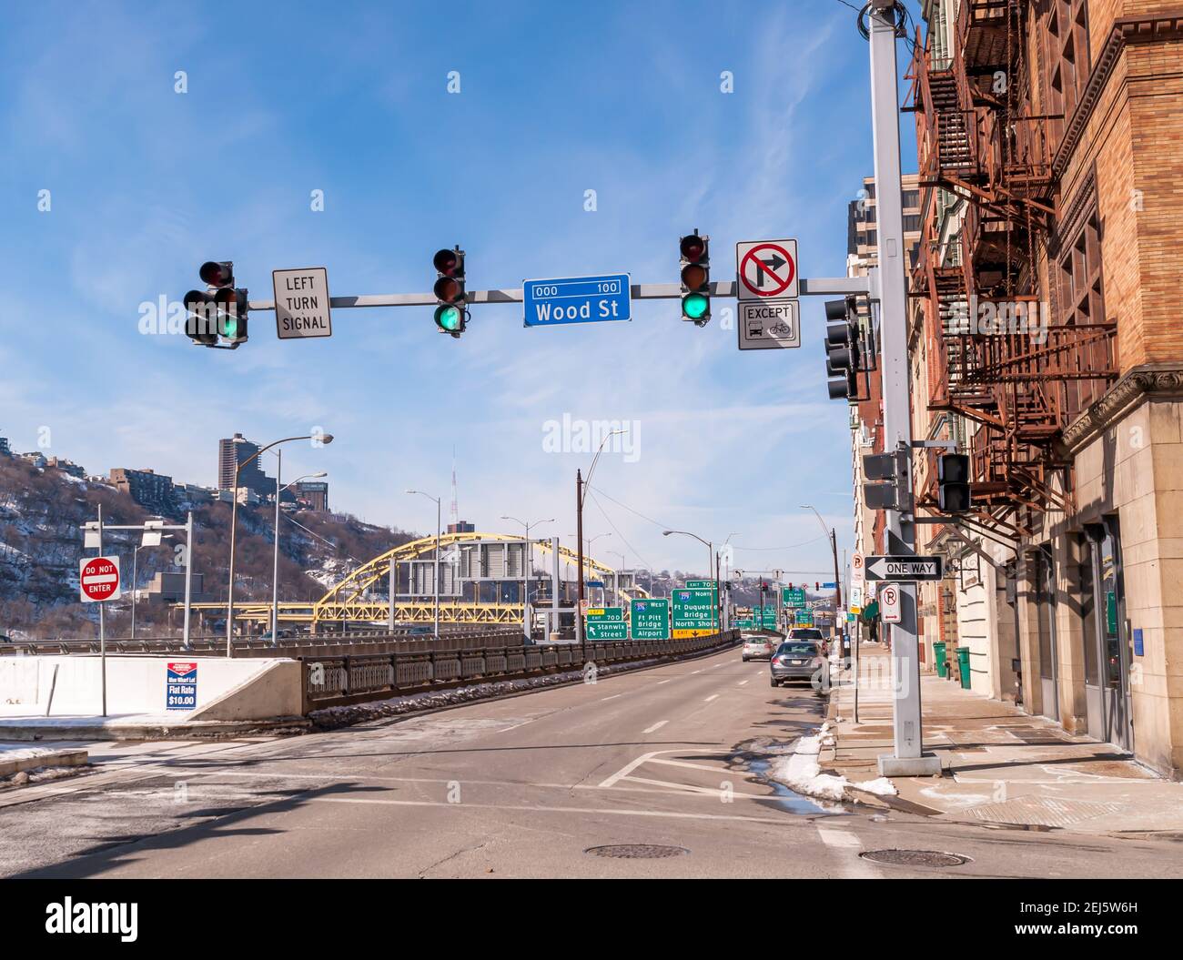 Geparkte Autos und Verkehr entlang Fort Pitt Boulevard mit der Fort Pitt Brücke im Hintergrund, Pittsburgh, Pennsylvania, USA Stockfoto