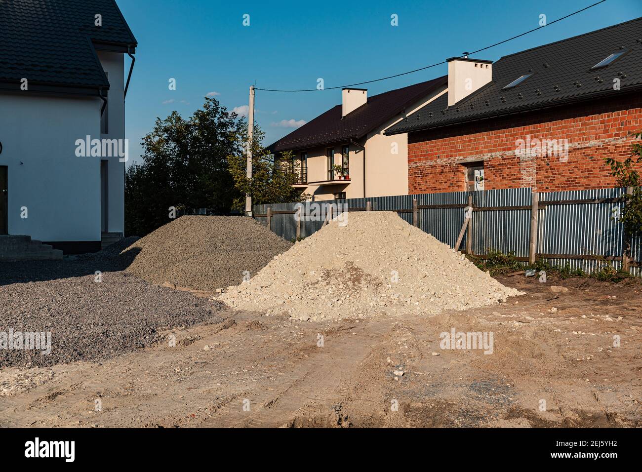 Zwei Haufen weißen Sandes mit Steinen und grauen Schutt auf der Baustelle. Material Rückfüllen. Aufbaukonzept. Stockfoto