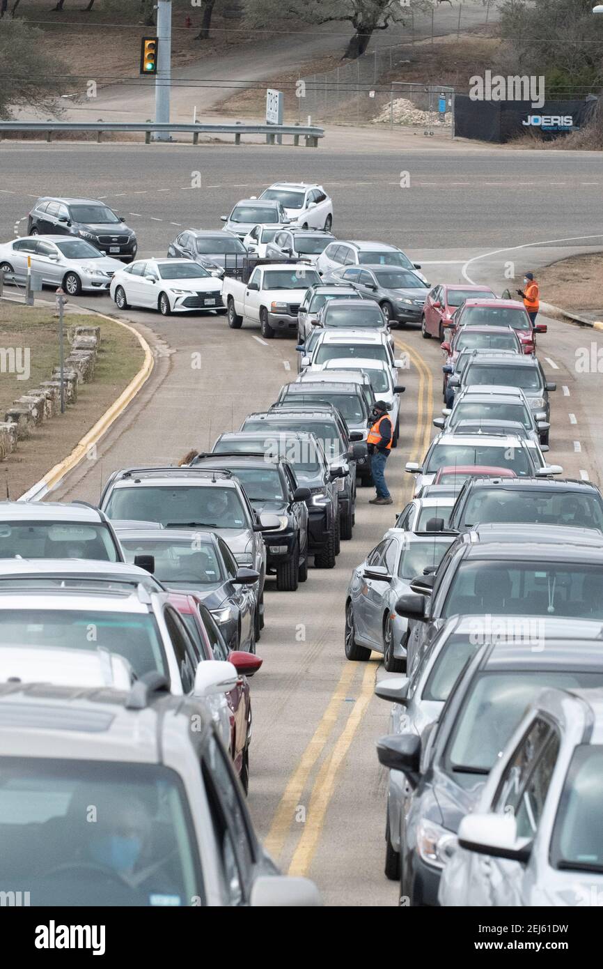 Oak Hill, TX USA 21. Februar 2021: Freiwillige organisieren eine lange Reihe von Fahrzeugen an einer Wasserabfüllstelle im westlichen Travis County, TX. Die Bewohner der Gegend haben seit mehreren Tagen kein fließendes Wasser mehr, weil letzte Woche der verheerende Schneesturm in Texas war. Fahrer durften nur einen Koffer pro Auto, nachdem einige drei Stunden in der Schlange standen. Kredit: Bob Daemmrich/Alamy Live Nachrichten Stockfoto