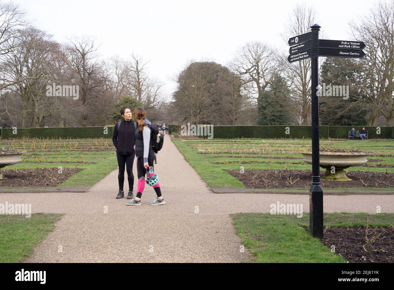 Zwei Frauen, die an der Kreuzung stehen und entscheiden, wie sie im London greenwich Park laufen sollen, an bewölktem Tag Stockfoto