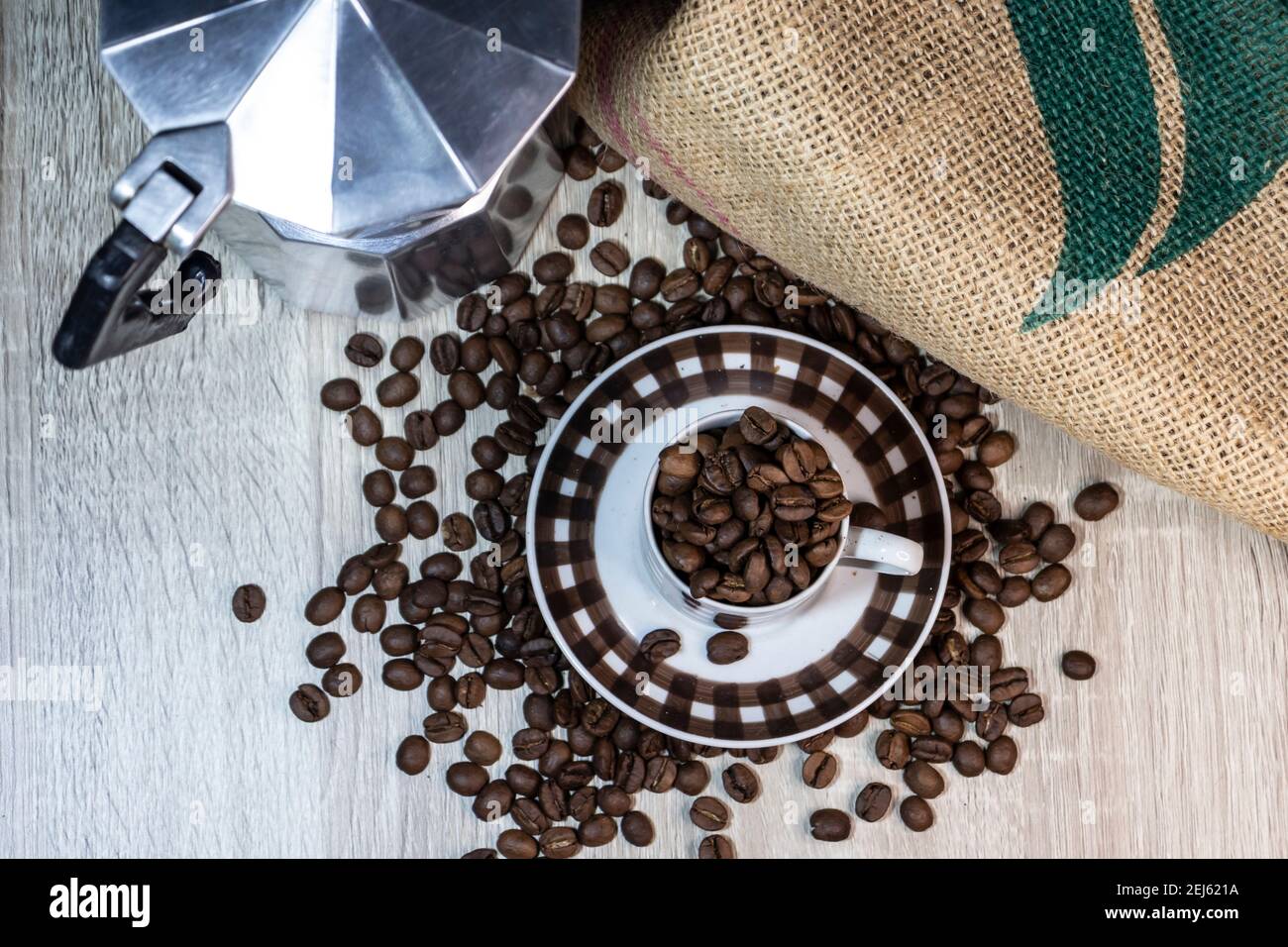Draufsicht auf Kaffeebohnen in einer Tasse und Italienisch Kaffeemaschine auf einem Holztisch in Brasilien Stockfoto