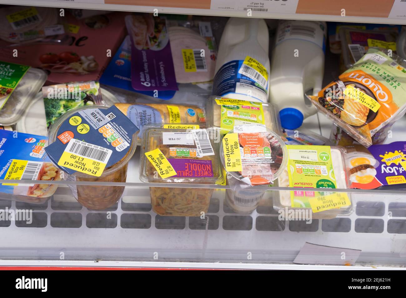 Preisgünstige Lebensmittel mit gelben Rabattetiketten sind in den Regalen in einem Londoner Sainsbury's Supermarkt zu sehen Stockfoto