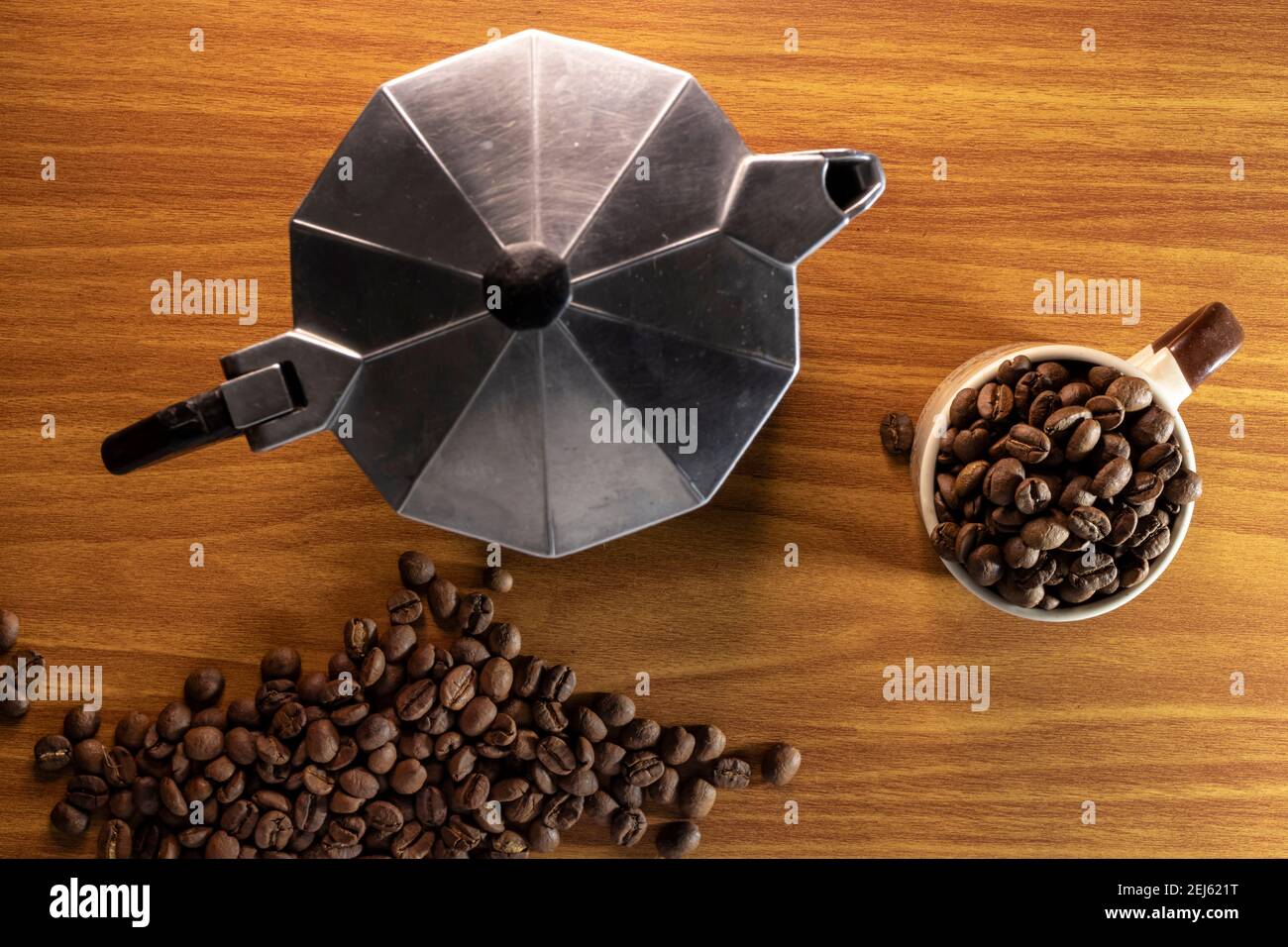 Draufsicht Kaffeebohnen in einer Tasse und italienischer Kaffee Hersteller auf einem Holztisch in Brasilien Stockfoto