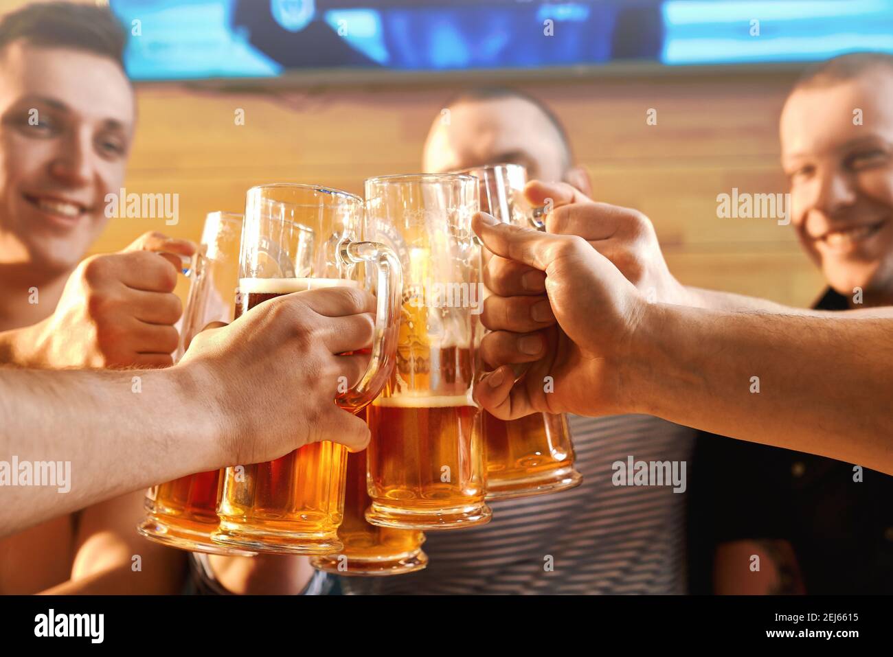 Selektiver Fokus der Gläser Bier in die Hände der freundlichen männlichen Freunden im Pub. Männliche Gesellschaft zusammen ruhen, Alkohol zu trinken und Toasten in der Kneipe. Konzept von Glück und trinken. Stockfoto