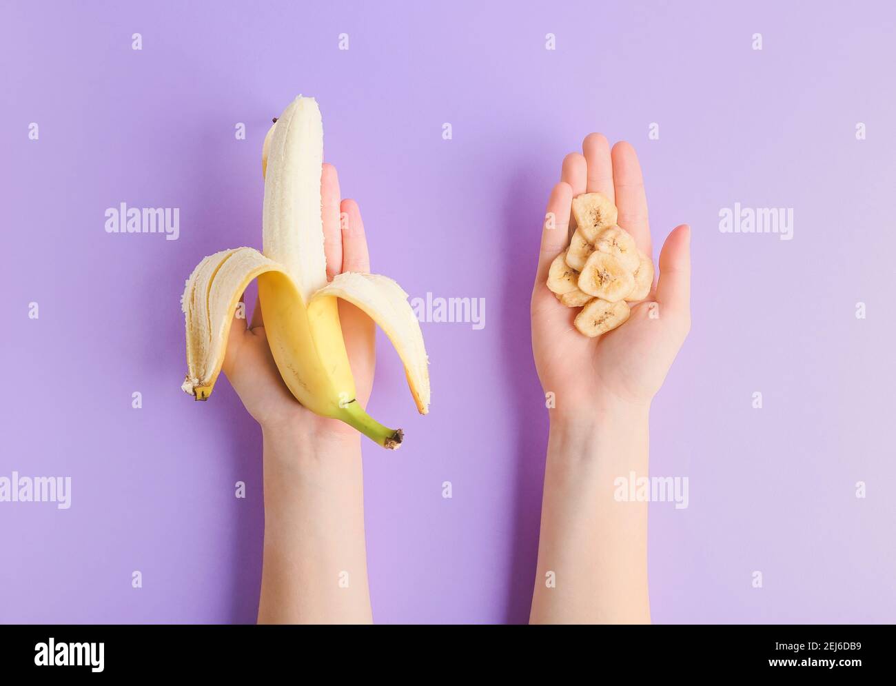 Frau hält frische Banane und knusprige Chips auf Farbhintergrund Stockfoto
