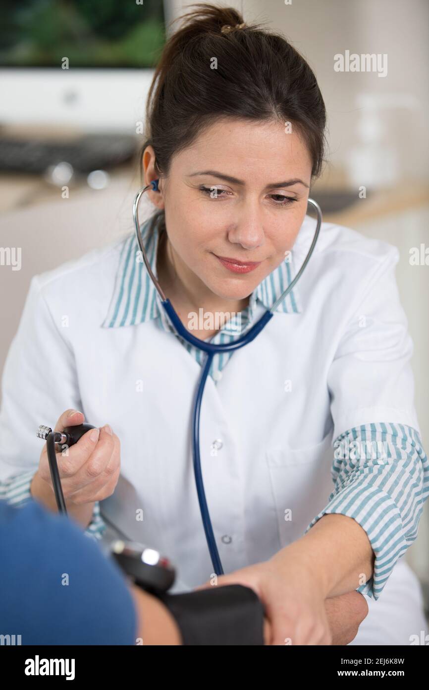 Junge Ärztin unter einem weiblichen Patienten Druck Stockfoto