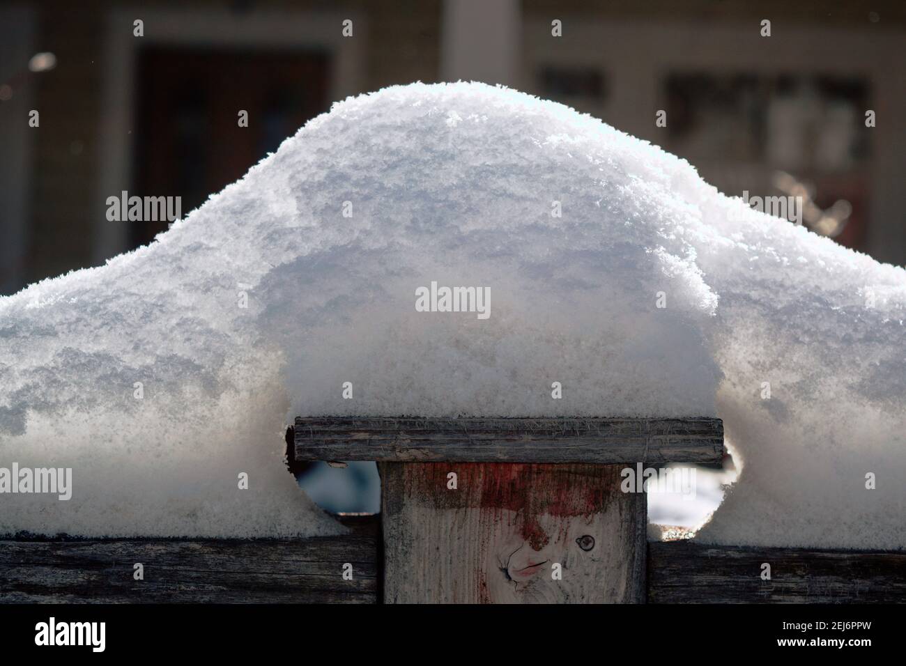 An einem sonnigen Tag in Ottawa, Ontario, Kanada, stapelte sich frisch gefallener Schnee auf einem Holzzaun. Stockfoto