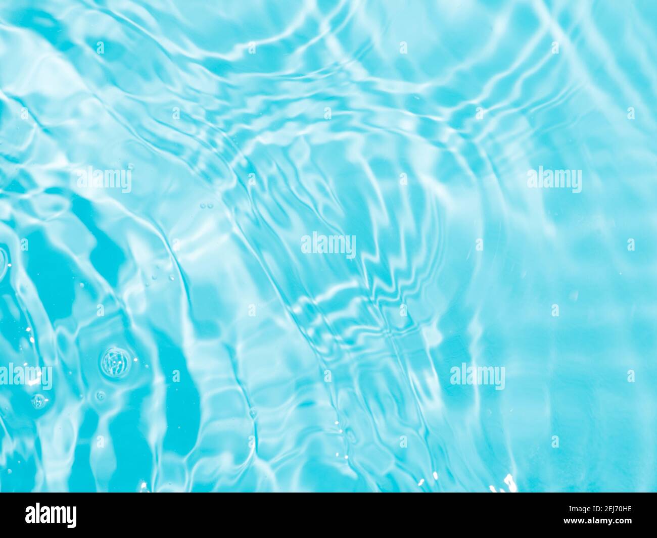 Verschwommenes Wellenwasser auf blauem Poolhintergrund. Schatten des Wassers auf Sonnenlicht. Modell für Produkt-, Spa- oder Reisehintergrund. Marmorblaue Wasseroberfläche als Hintergrund Stockfoto
