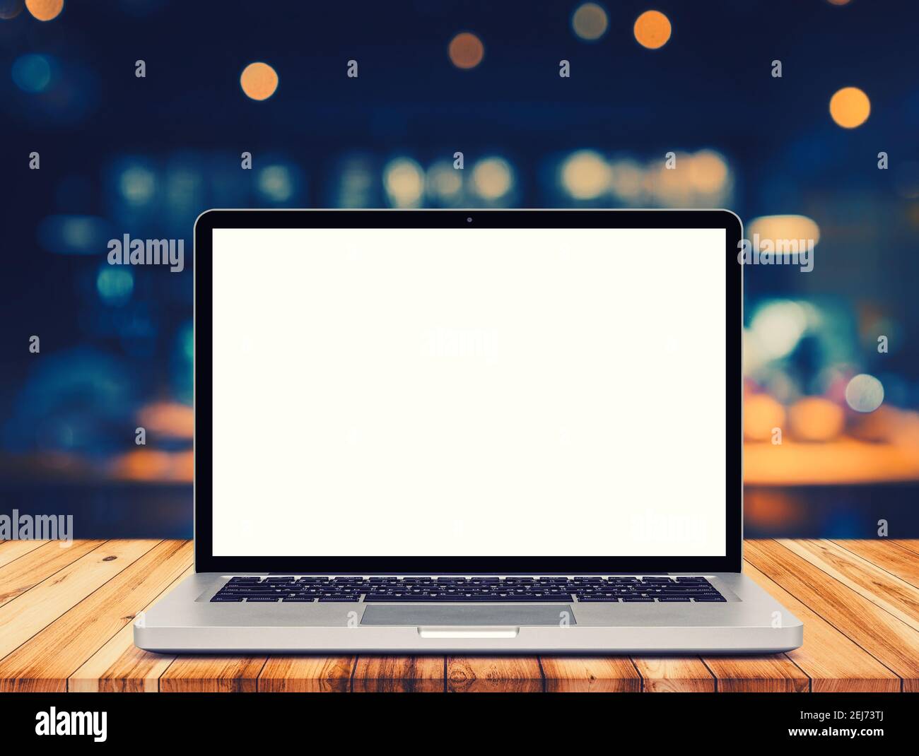 Laptop mit leerem Bildschirm auf dem Tisch, Café verschwommener Hintergrund von Bokeh. Stockfoto