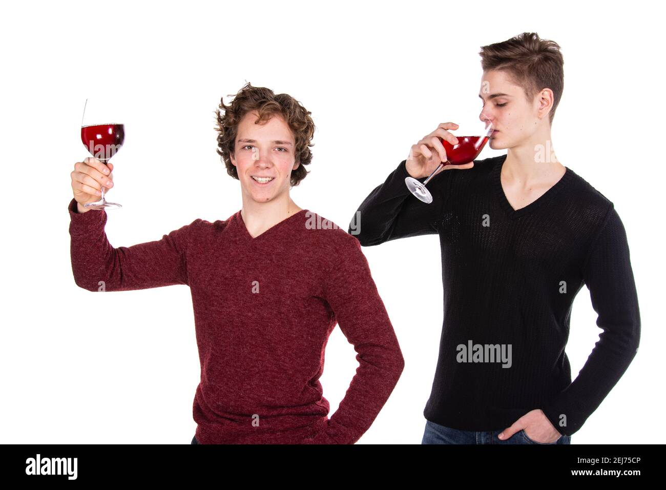 Feiertage und Wochenenden. Junges attraktives Paar trinkt Rotwein. Weißer Hintergrund. Stockfoto