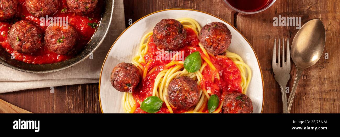 Fleischbällchen mit Pasta, über dem Kopf flach Lay Panorama auf einem rustikalen Holzhintergrund Stockfoto