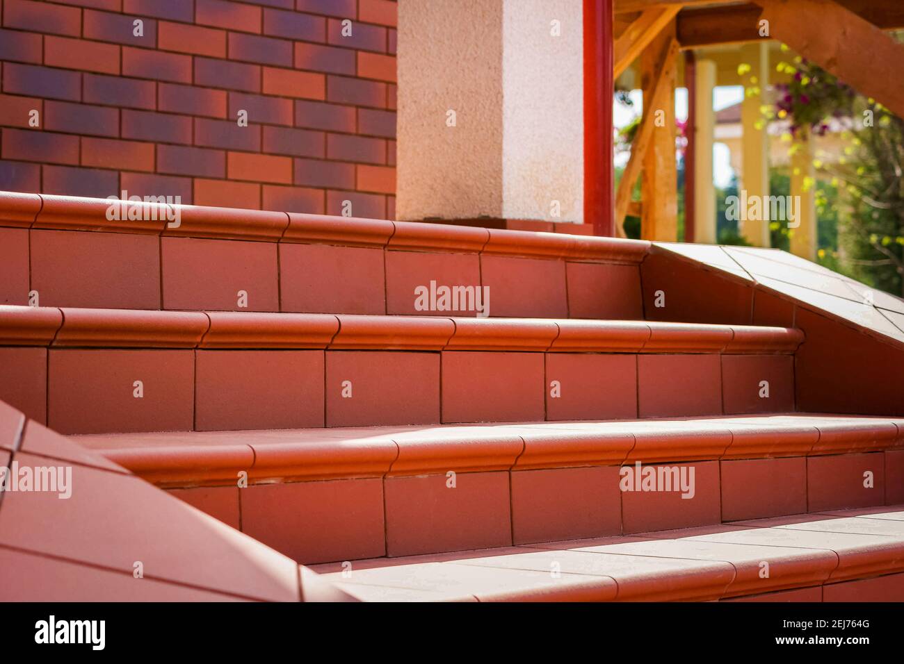 Stufen aus braunen Klinkerfliesen. Cottage Veranda Stockfoto