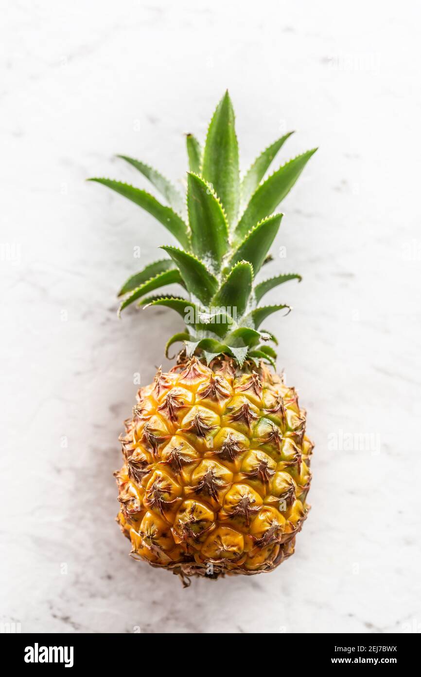 Frische ganze Ananas mit Blättern auf einer Marmoroberfläche. Stockfoto