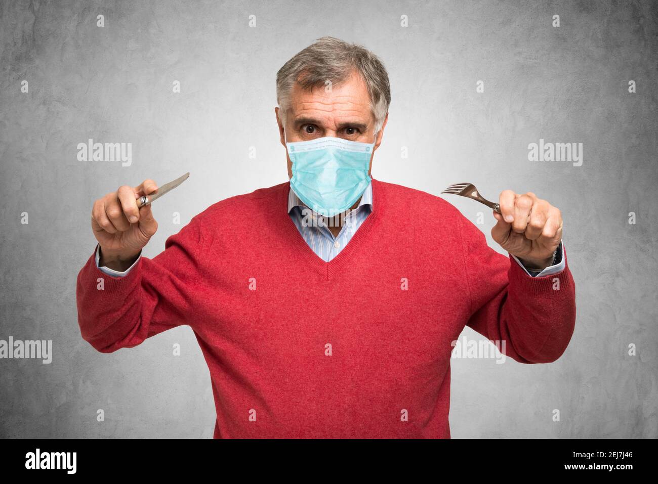 Hungriger maskierter Mann, covid Coronavirus lustiges Konzept Stockfoto