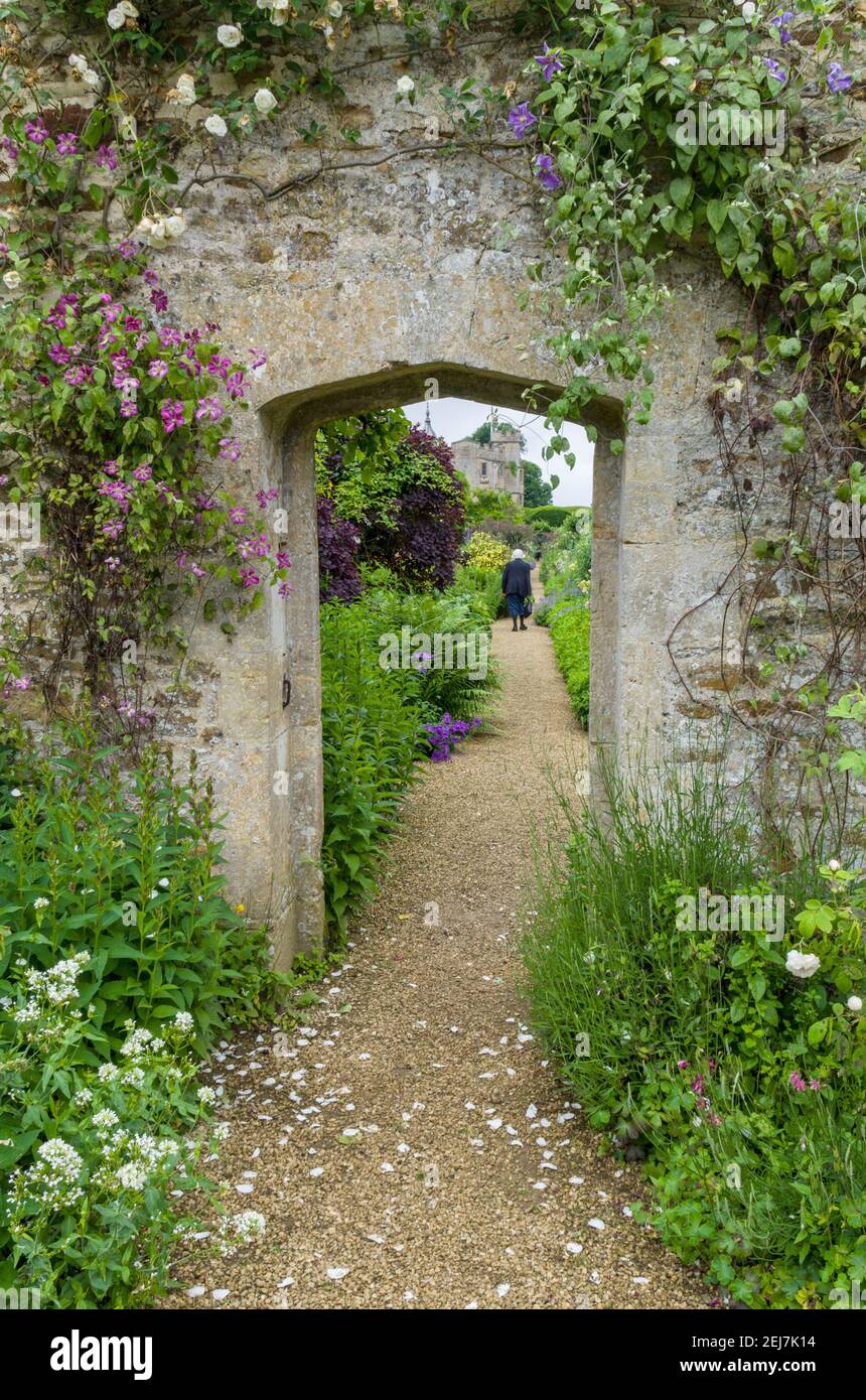 Gärten im Rousham House, Oxfordshire, Großbritannien; Torbogen und Bepflanzung im ummauerten Garten. Stockfoto