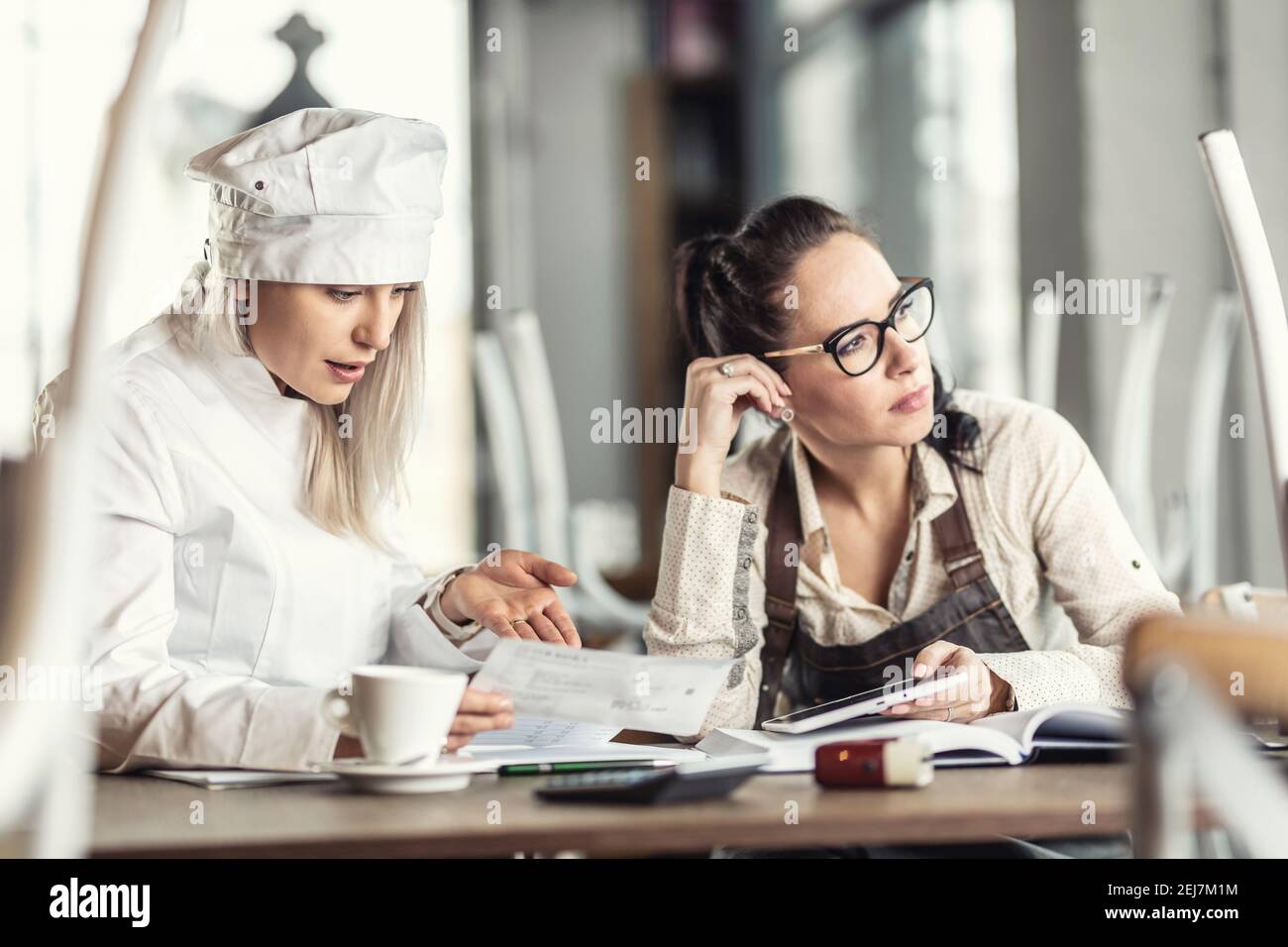 Restaurantmitarbeiter, die von den Coronacrisis hart getroffen werden, denken über die Zukunft des Geschäfts über Rechnungen in einem geschlossenen Betrieb nach. Stockfoto