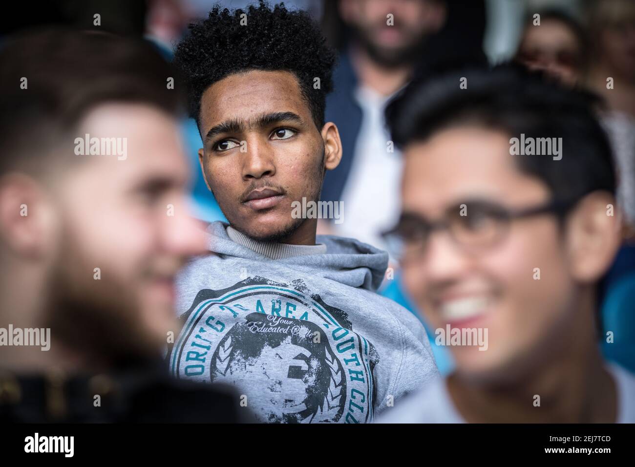 Intimes Porträt eines jungen afrikanischen Mannes, der ein Fußballspiel im Fußballsender Leeds, Großbritannien, ansieht. Soziale Integration von Flüchtlingen Stockfoto