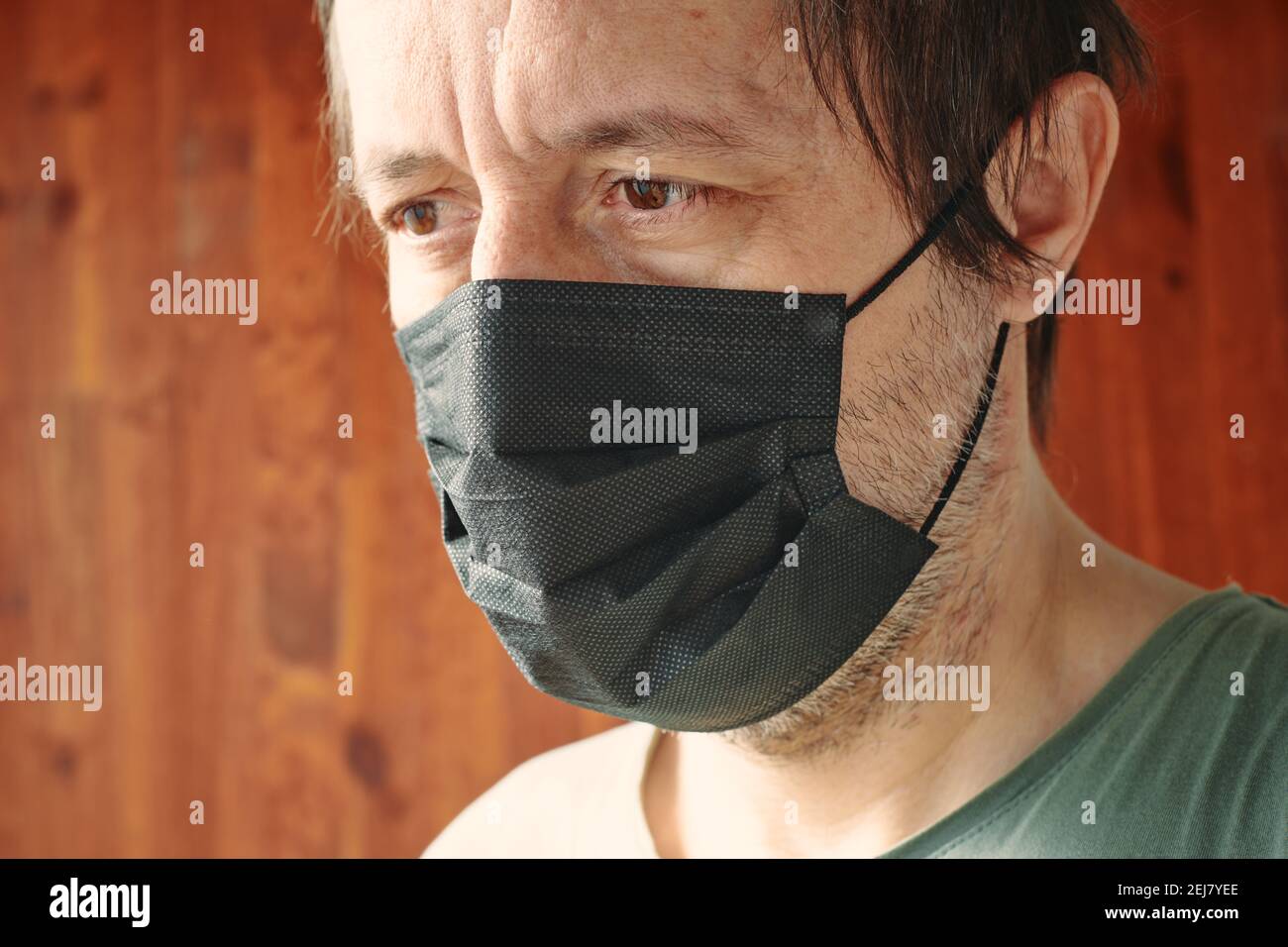 Porträt des kaukasischen Mannes mit schwarzer chirurgischer Schutzmaske während der Pandemien von Covid-10, selektiver Fokus Stockfoto
