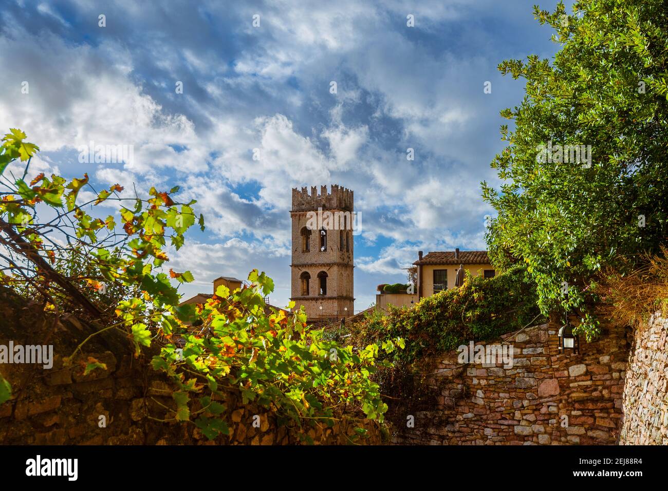 Assisi charmante mittelalterliche Altstadt mit dem alten Torre del Popolo (Volksturm) und stürmische Wolken darüber Stockfoto