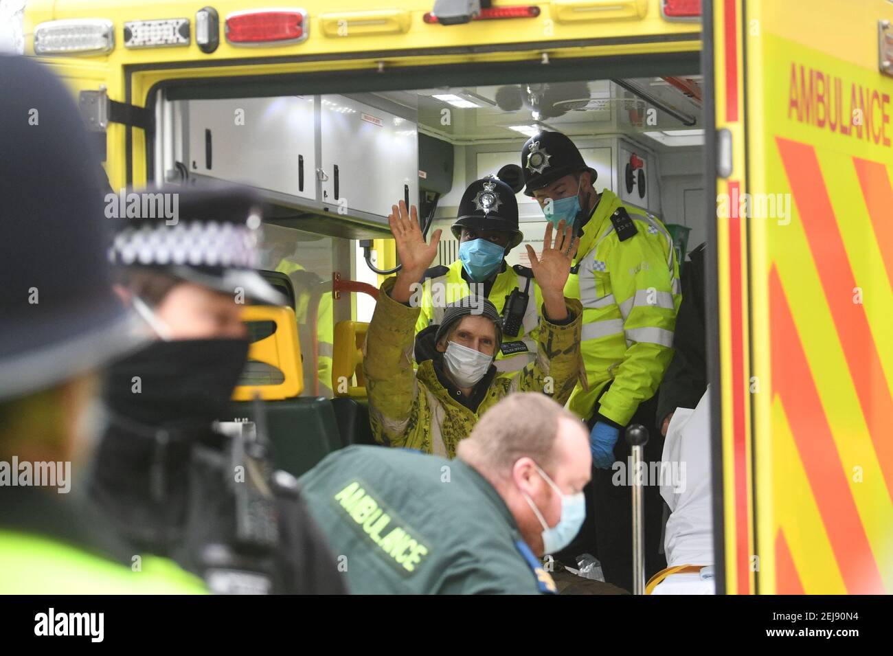 Ein Anti-HS2-Aktivist, bekannt als "Lärche", winkt von der Rückseite eines Krankenwagens in Euston Square Gardens, London, nachdem er von Gerichtsvollziehern aus einem Tunnel von 100ft, wo er protestiert hatte, entfernt wurde. Bilddatum: Montag, 22. Februar 2021. Stockfoto