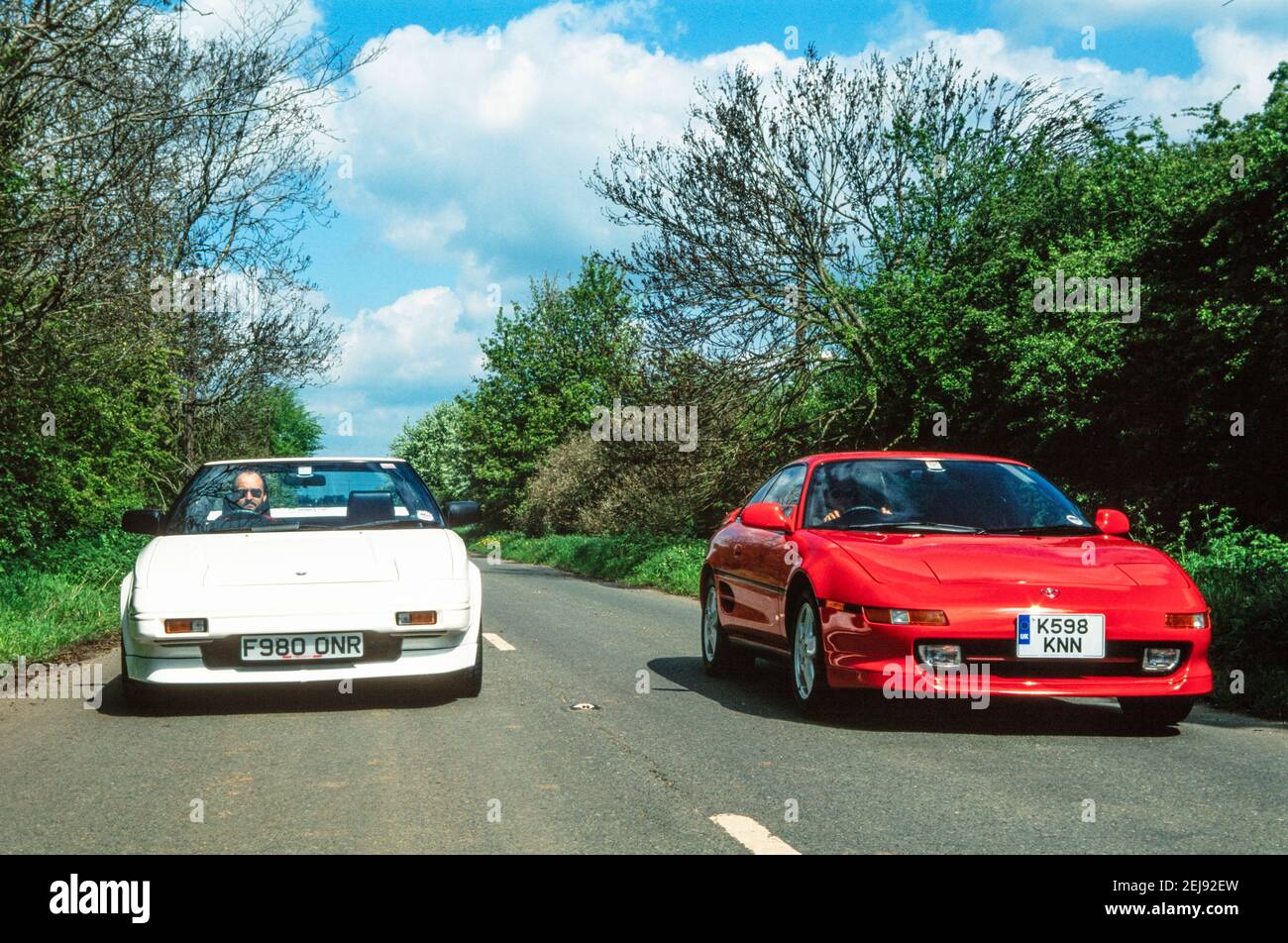 1998 England zwei Toyota mr2 Autos - EIN roter Japaner Import Toyota MR2 MK2 Turbo und ein weißer Toyota MR2 Mk1 Auto mit dem weißen MR2 mk1 mr2 überholen die Red Toyota MR2 MK2 Turbo auf einer Landstraße England GB UK Europa Stockfoto