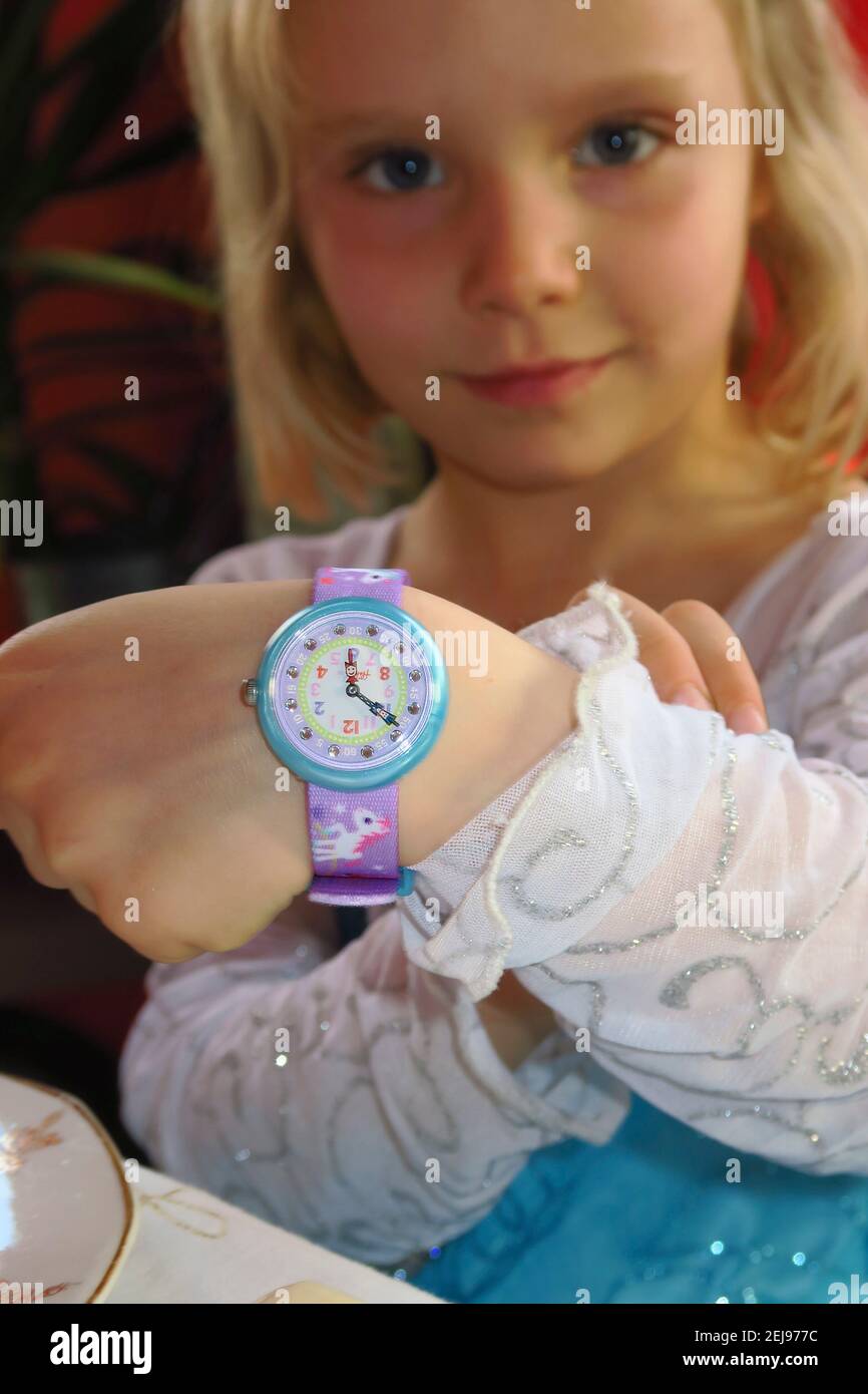 4-5-jähriges Mädchen mit ihrer Uhr, um die zu lernen Zeit Stockfoto