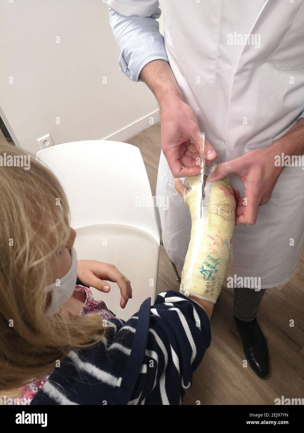 MÃ©decin Coupant le plÃ¢tre au ciseaux d'une fillette de 8 ans au poignet cassÃ© il y a 6 semaines, europÃ©enne, Frankreich. Stockfoto