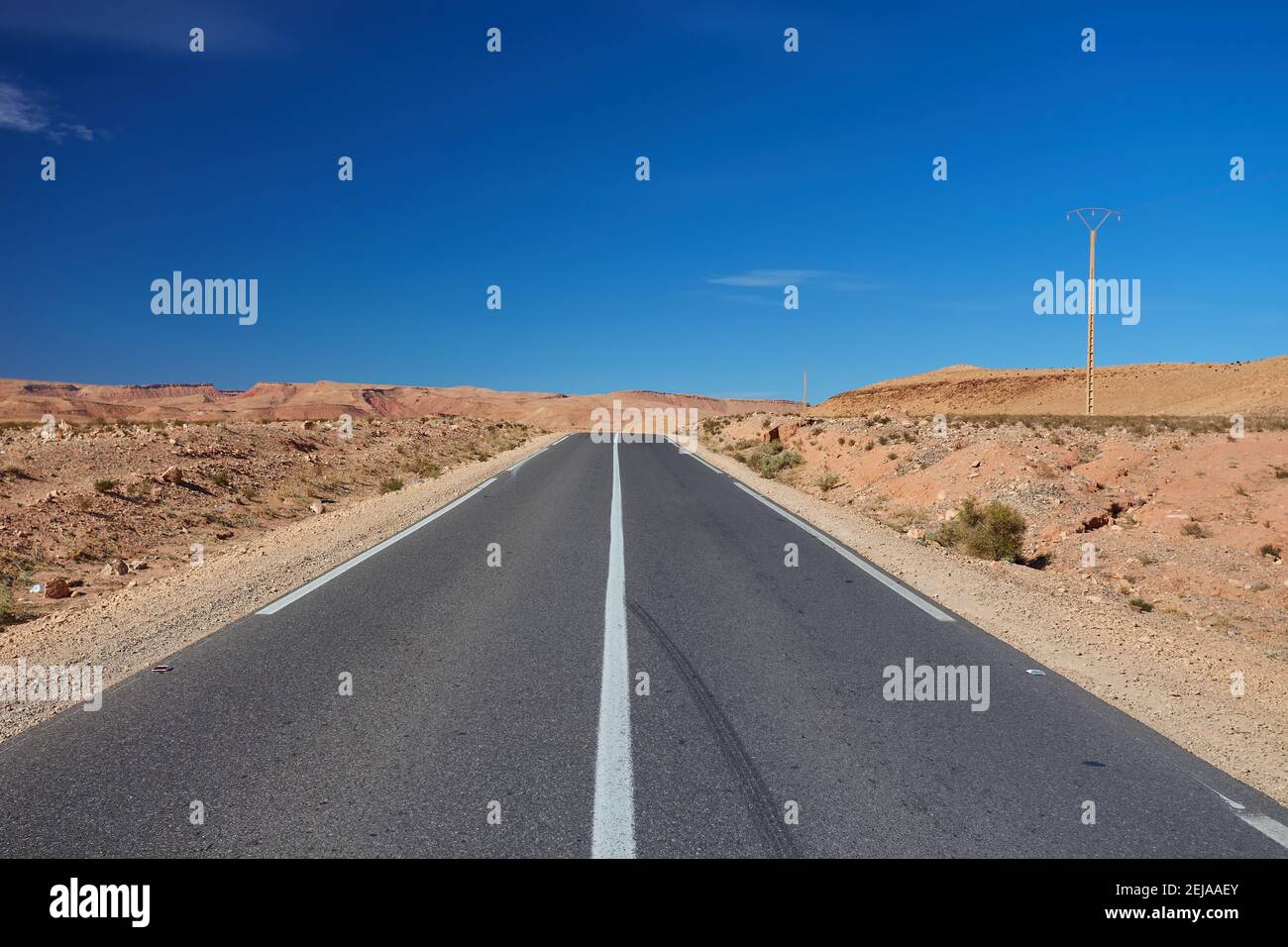 Straße nach Marrakesch. Meilenstein, der Marrakesch in einem desertischen Gebiet von Marokko anzeigt Stockfoto