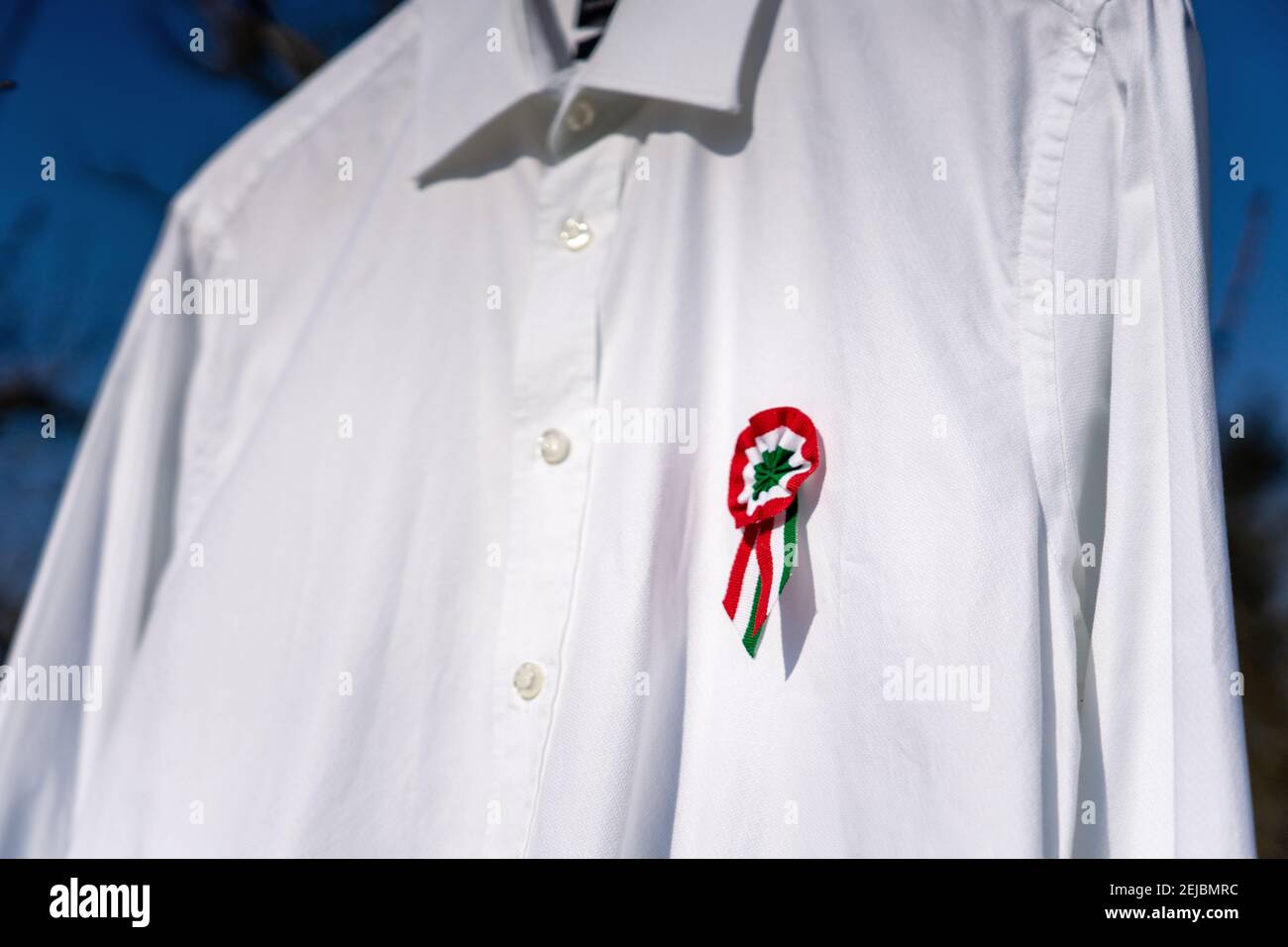 Weißes Hemd hängend draußen mit tricolor Rosette Symbol der ungarischen Nationalfeiertag 15th märz . Stockfoto