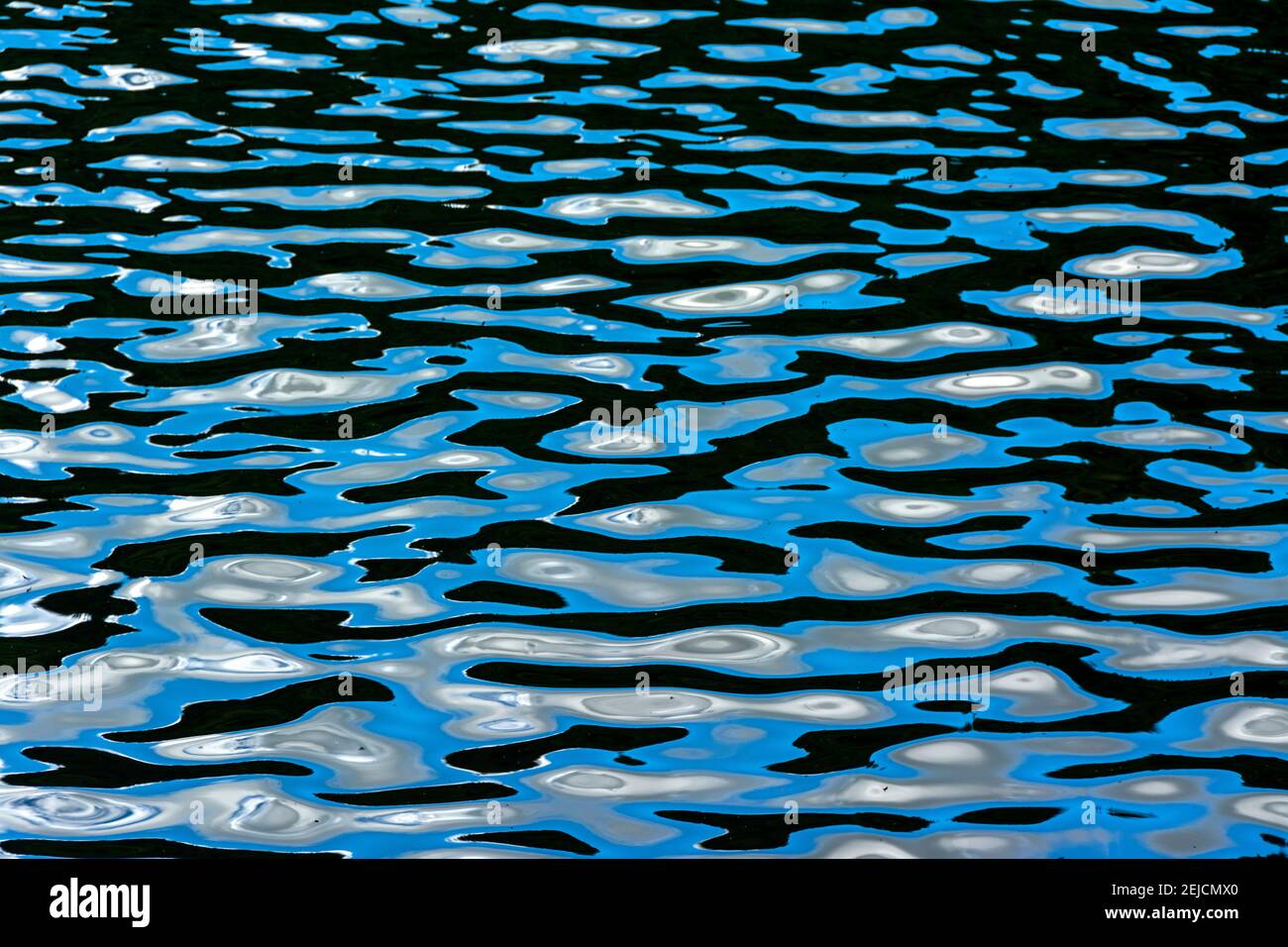 Reflexionen auf blauem Wasser in ruhiger Natur während der Tageslichtstunde Stockfoto