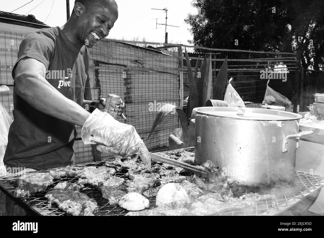 JOHANNESBURG, SÜDAFRIKA - 20. Feb 2021: Soweto, Südafrika - 10. September 2011: Afrikanischer Mann, der einen BBQ Grill auf einer Nebenstraße in der Stadt Soweto arbeitet Stockfoto