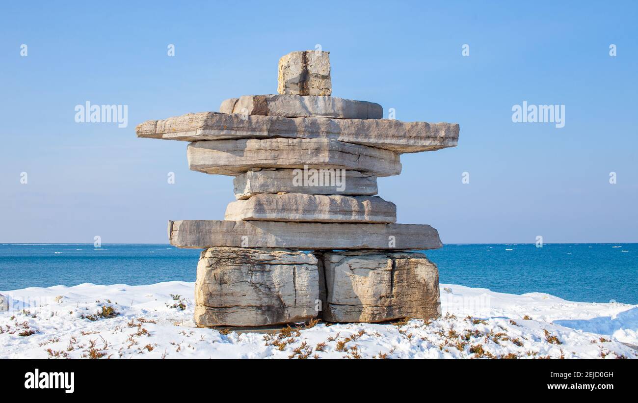 Ein riesiger Inukshuk steht mit Blick auf die Georgian Bay im Collingwood's Sunset Point Park. Ein Denkmal in der Gemeinde, zu Ehren eines lokalen Mannes. Stockfoto
