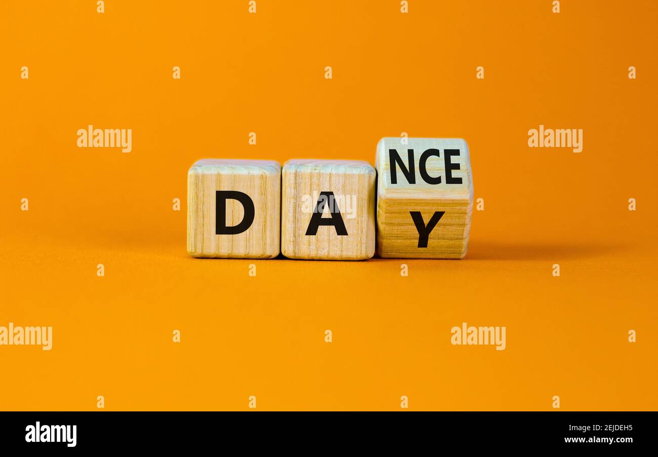 Symbol für den Internationalen Tanztag. Drehte den Würfel mit den Worten 'Tanztag'. Schöner orangefarbener Tisch, orangefarbener Hintergrund, Kopierbereich. Internationaler Tanztag Stockfoto