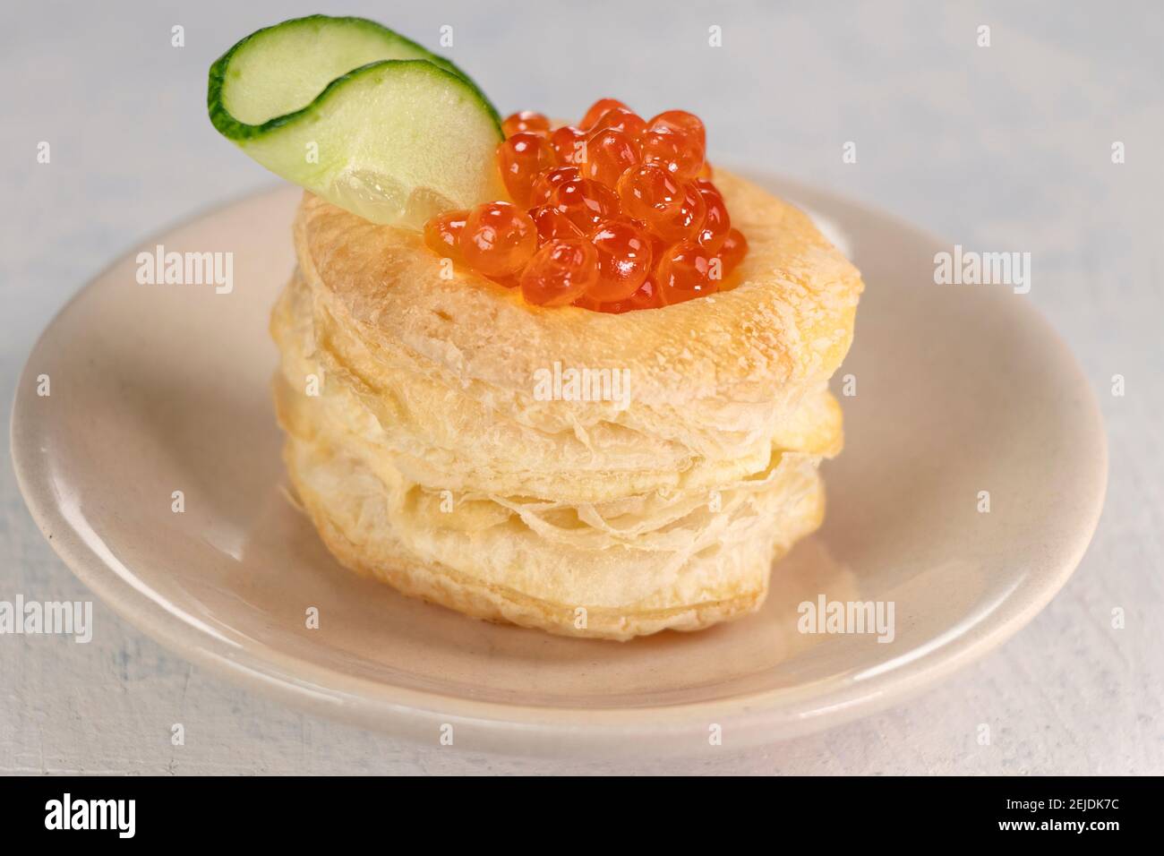 Vorspeise mit rotem Kaviar. Tartlets, roter Kaviar, Gurke auf weißem Hintergrund. Köstliche und gesunde Snack. Draufsicht Stockfoto