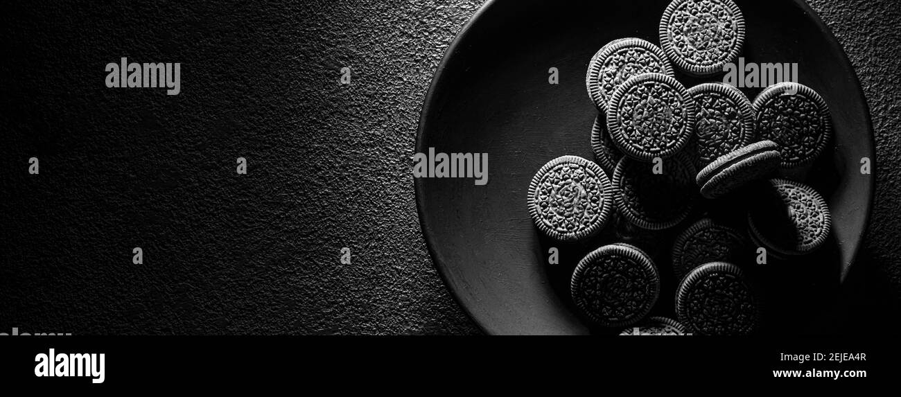 Strukturierte Kekse in einem schwarzen Teller auf einem dunklen Hintergrund, Art Food Konzept. Stockfoto