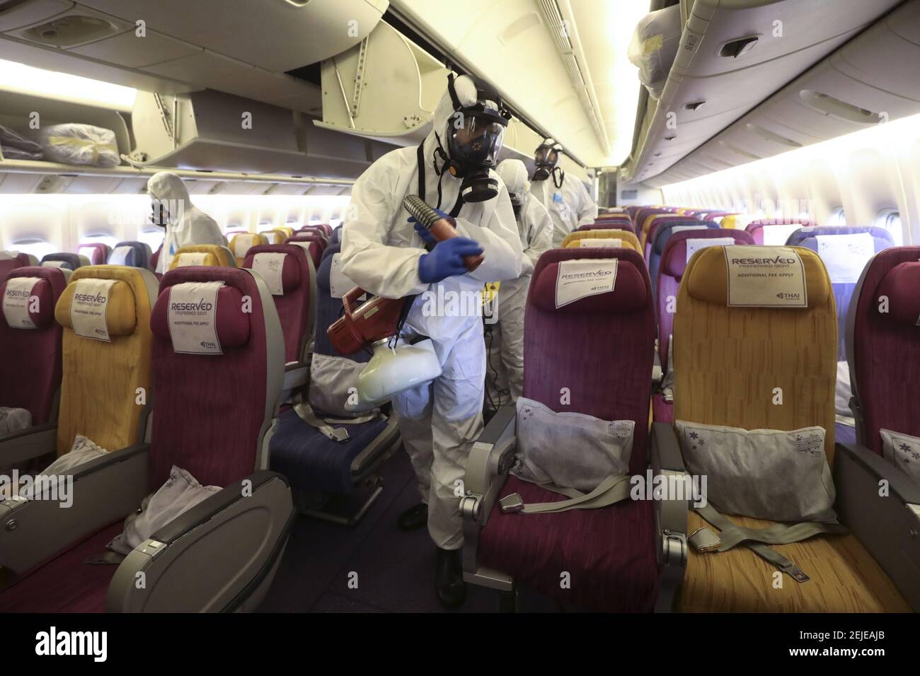 Crew-Mitglieder in Schutzanzügen und Masken sprühen während des  Desinfektionsprozesses. Thai Airways International sprüht  Desinfektionsmittel auf Passagiersitzen im Flugzeug nach einer riskanten  Corona-Virus-Infektion. Thailand hat 14 Fälle entdeckt ...
