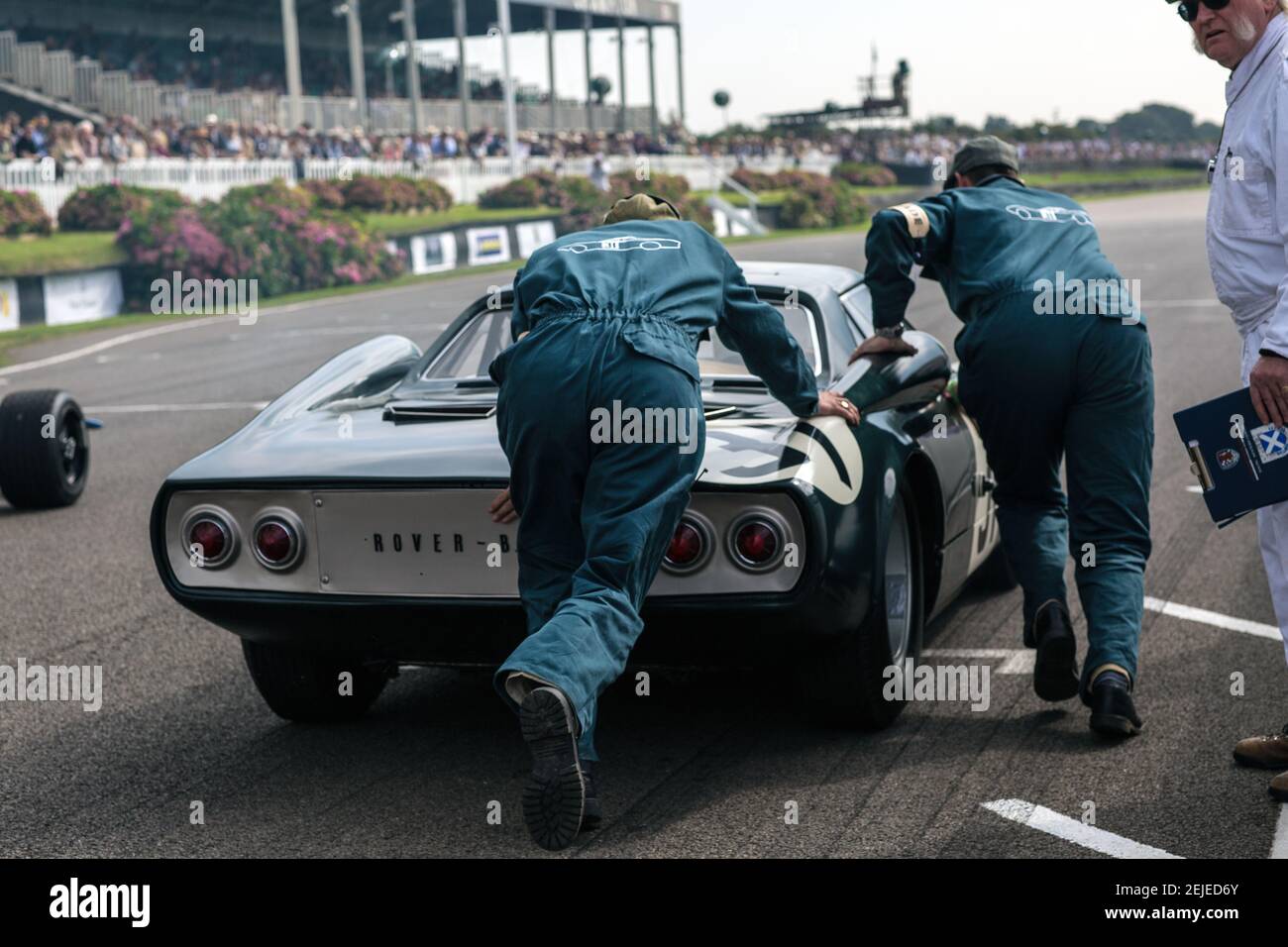 Two man Pushing Rover BRM Gas Turbine Race Car beim Goodwood Revival, West Sussex, England. Stockfoto