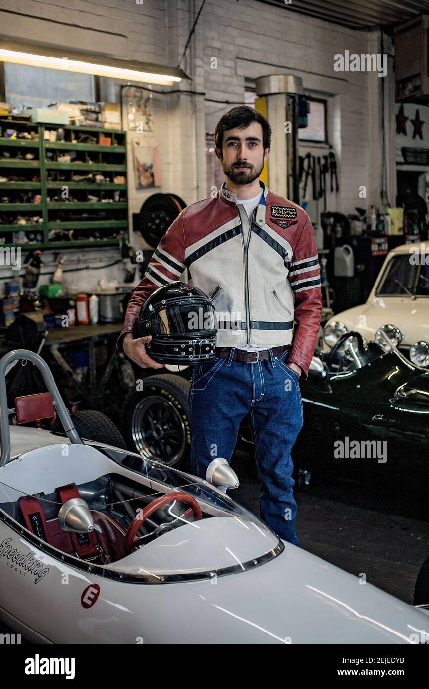 Racer Holding Helm in garage Stockfoto