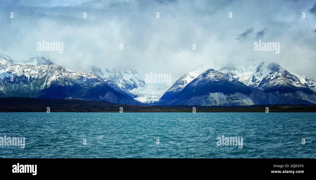 See mit schneebedeckten Bergen im Hintergrund, Lago Argentino, Provinz Santa Cruz, Patagonien, Argentinien Stockfoto