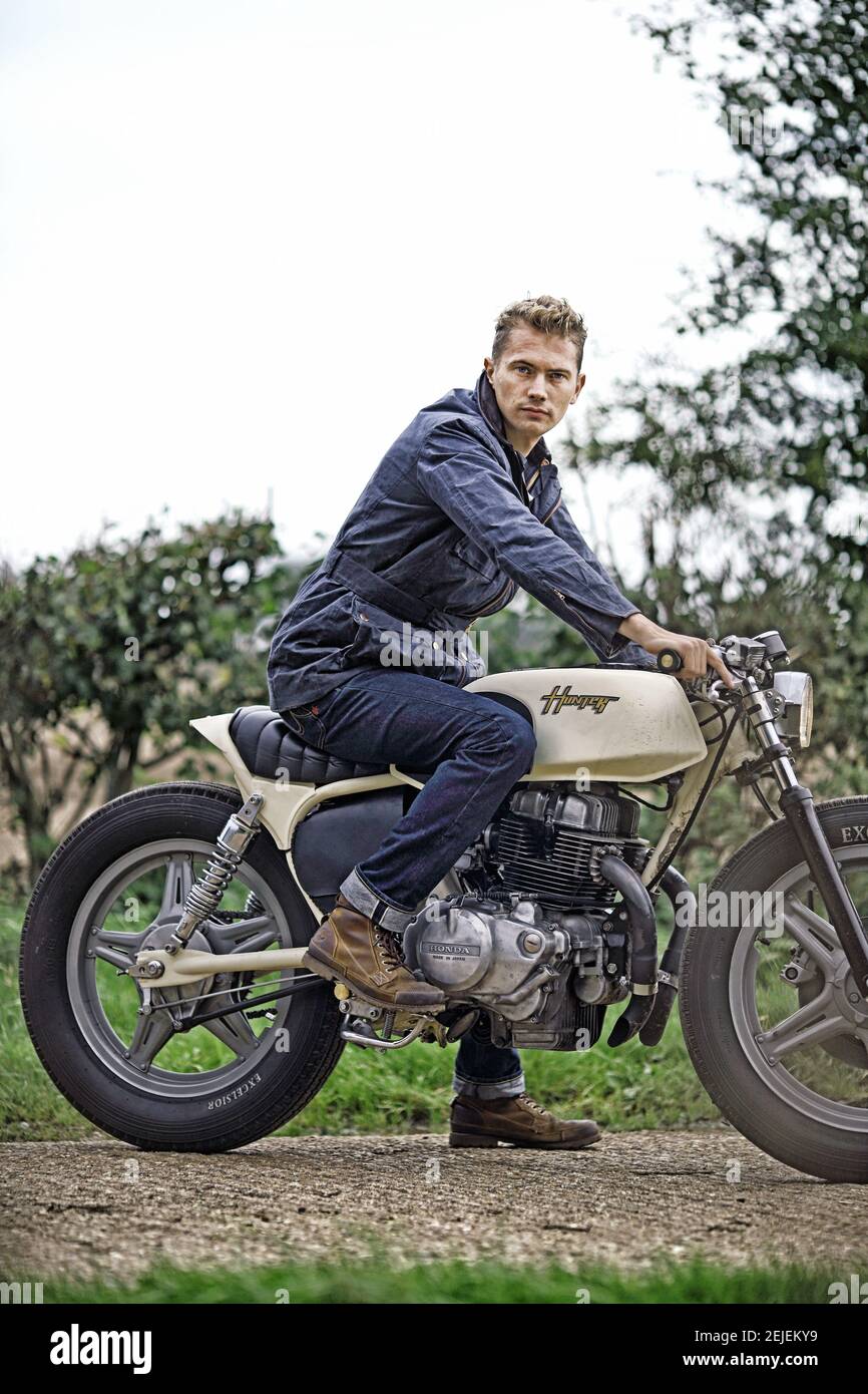 Schöner Mann auf Motorrad. Mann auf Motorrad in Jeans Denim. Biker Mann auf Motorrad. Stockfoto