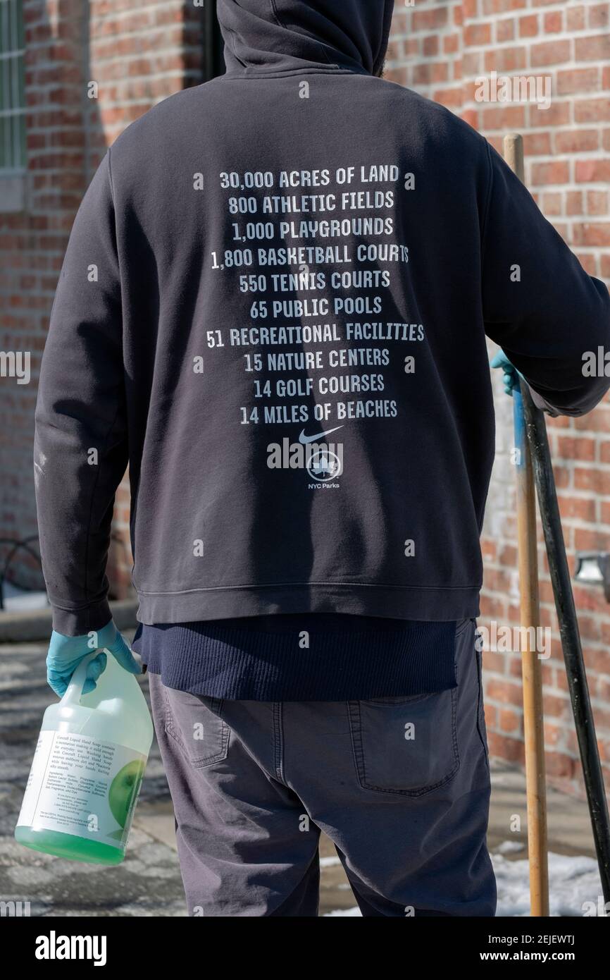Ein anonymer Arbeiter der New Yorker Parkabteilung, der von hinten fotografiert wurde und ein Sweatshirt trägt, das die Angebote der New Yorker Parks anpreist. In Queens, NYC. Stockfoto