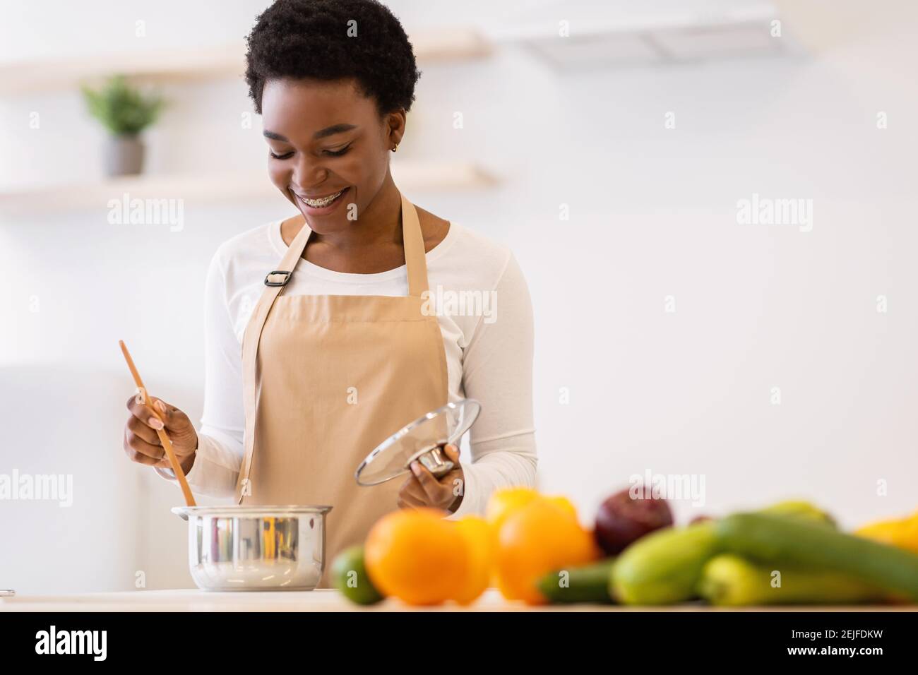 Afrikanische Frau Kochen Abendessen Stehend In Der Modernen Küche Zu Hause Stockfoto