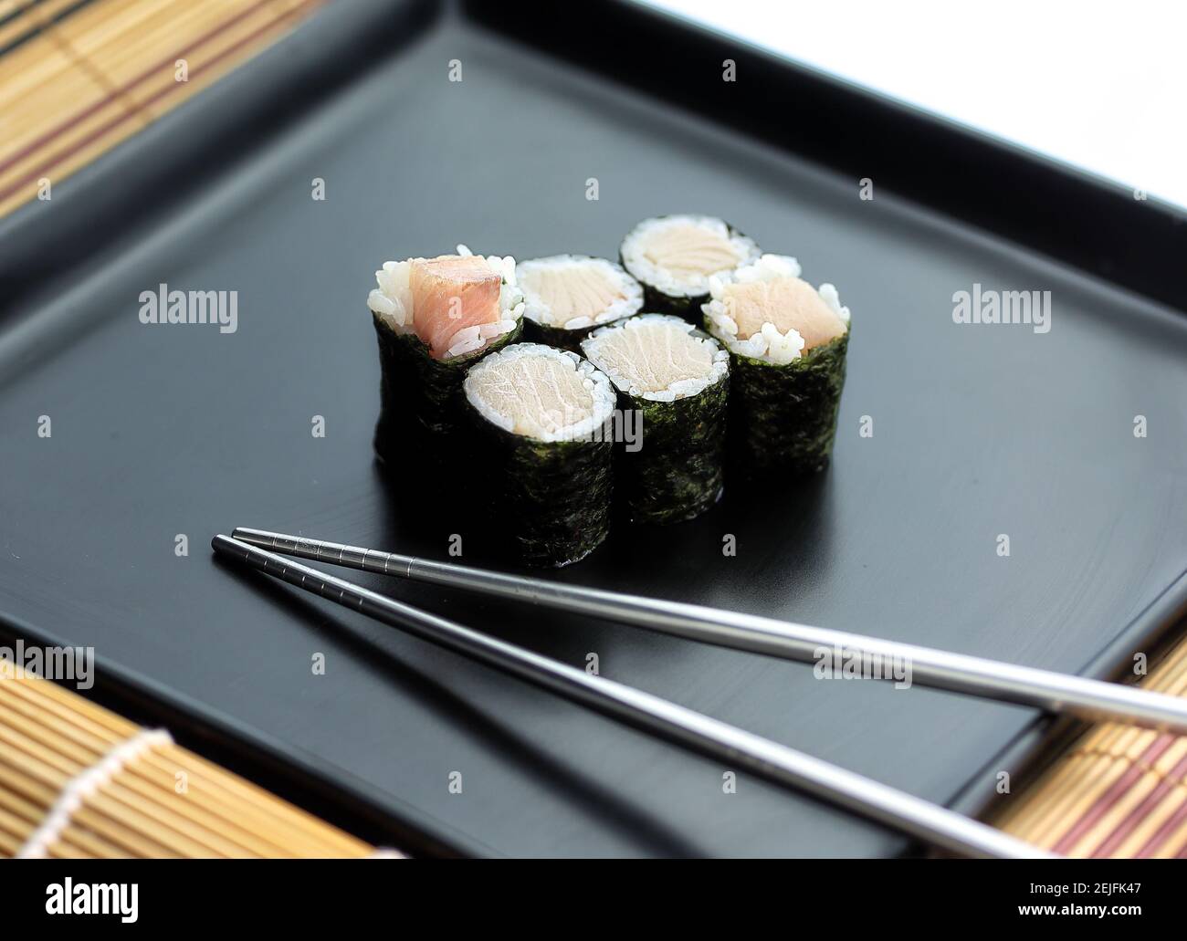 Köstliches Sushi-Set auf einem Teller mit Essstäbchen Stockfoto