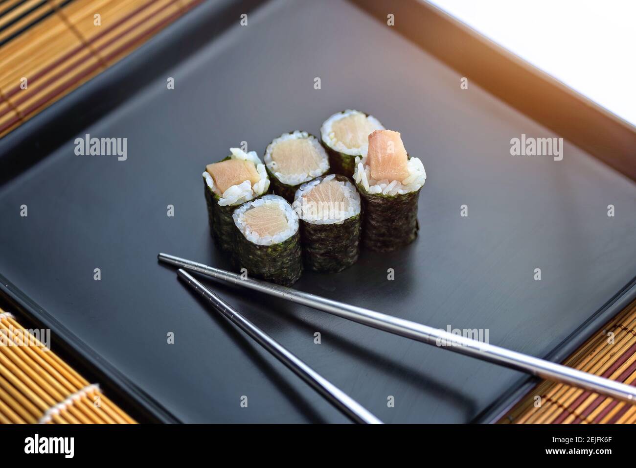 Köstliches Sushi-Set auf einem Teller mit Essstäbchen Stockfoto