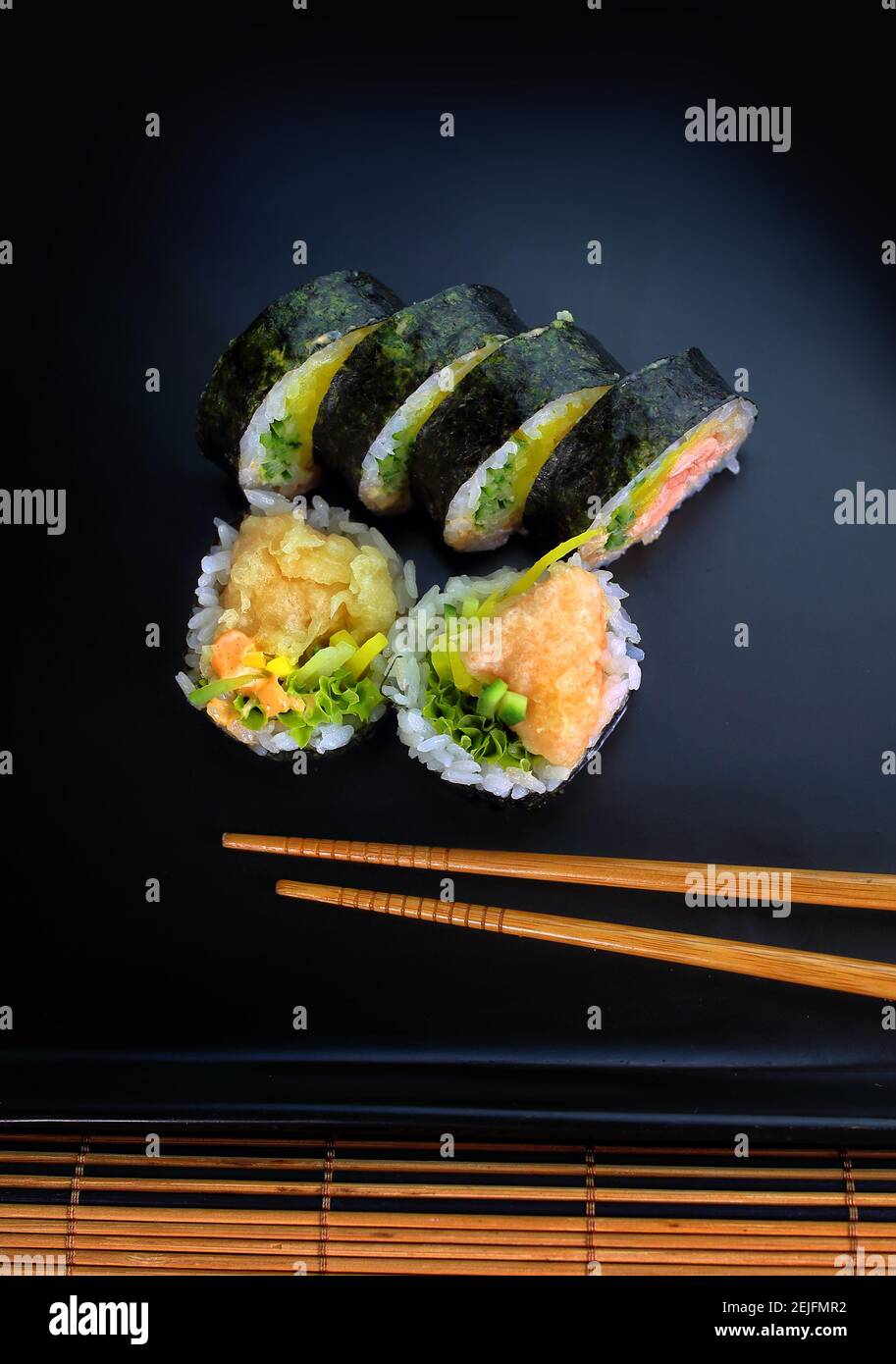 Sushi-Rolle auf einem schwarzen Teller bereit, serviert werden Stockfoto