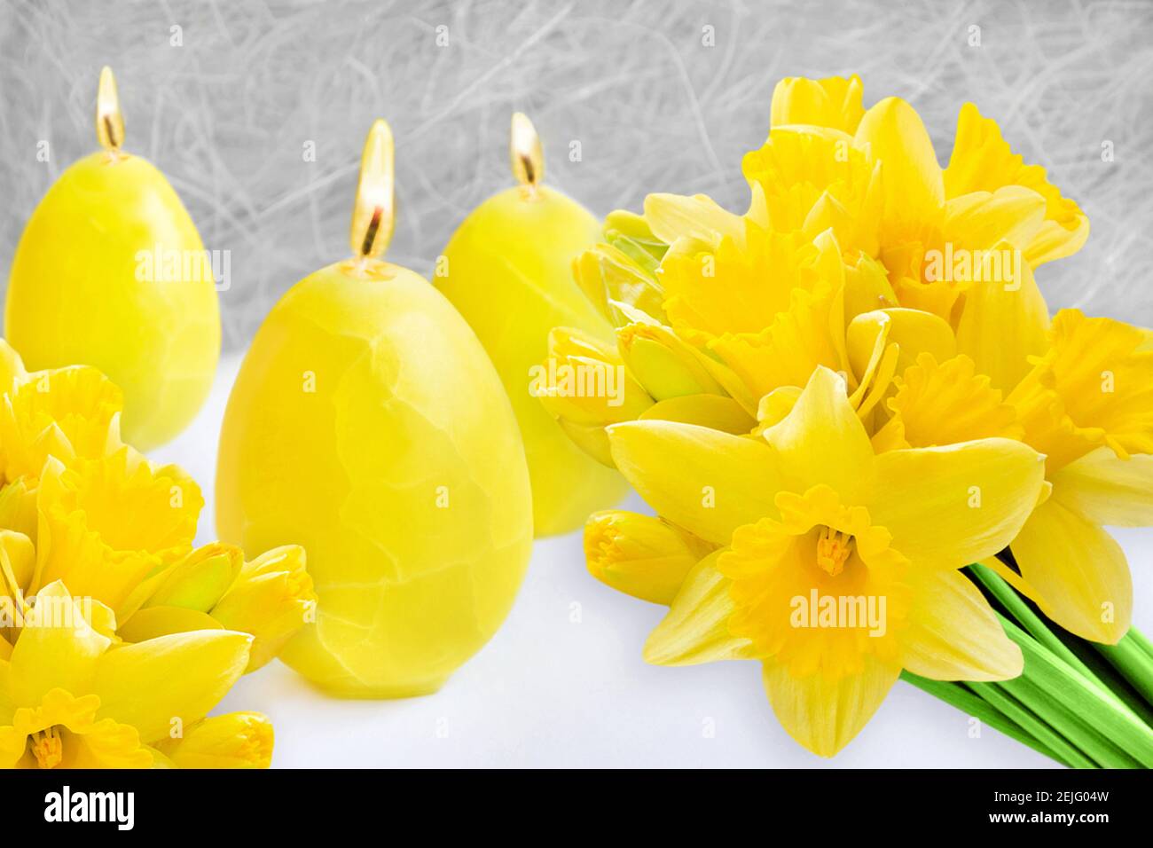 Gelbe Osterdekoration mit Kerzen und Narzissen Stockfoto