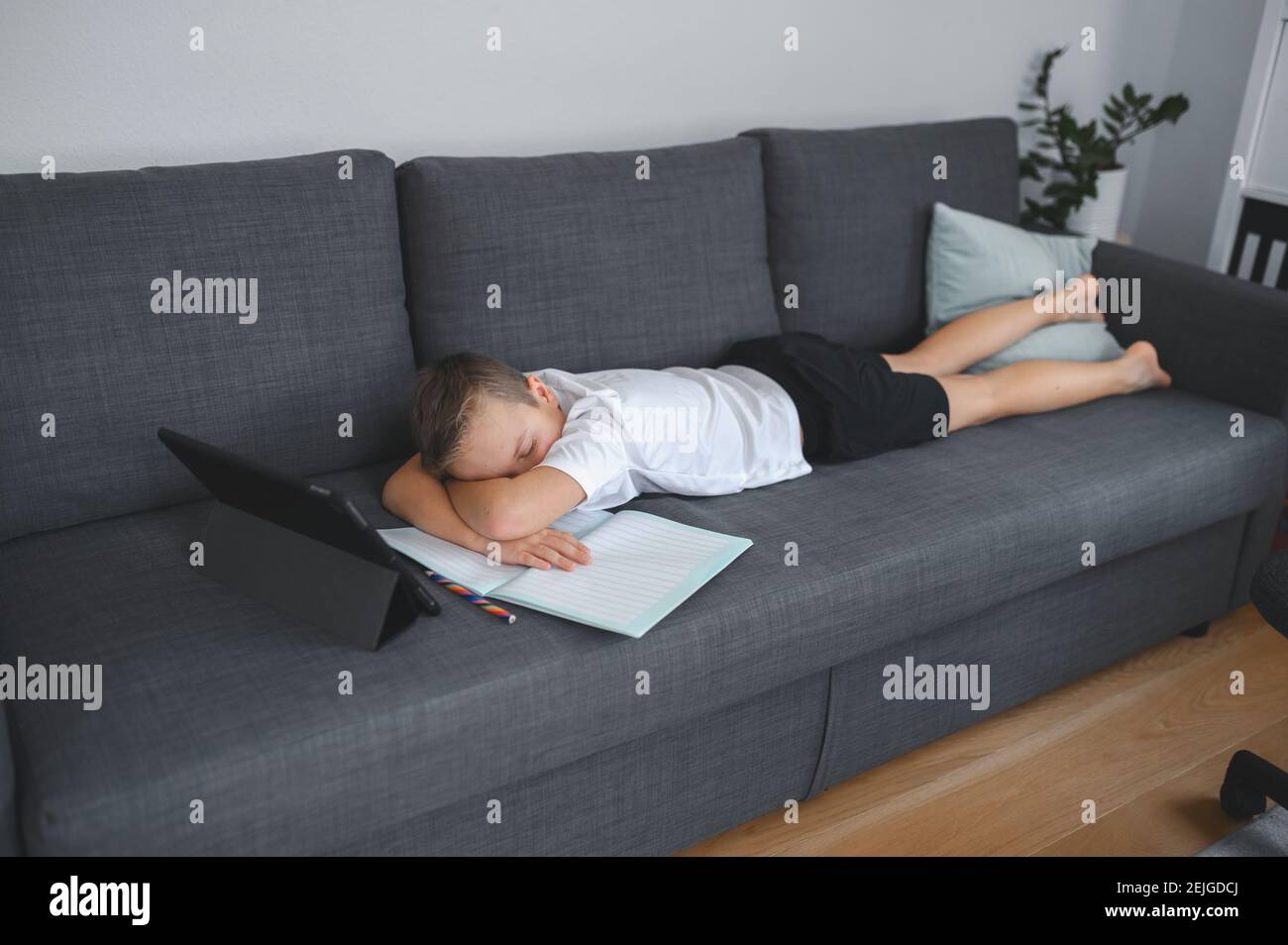 Online-Bildung, Homeschooling. Schuljunge mit Online-Unterricht zu Hause auf dem Trainer Stockfoto