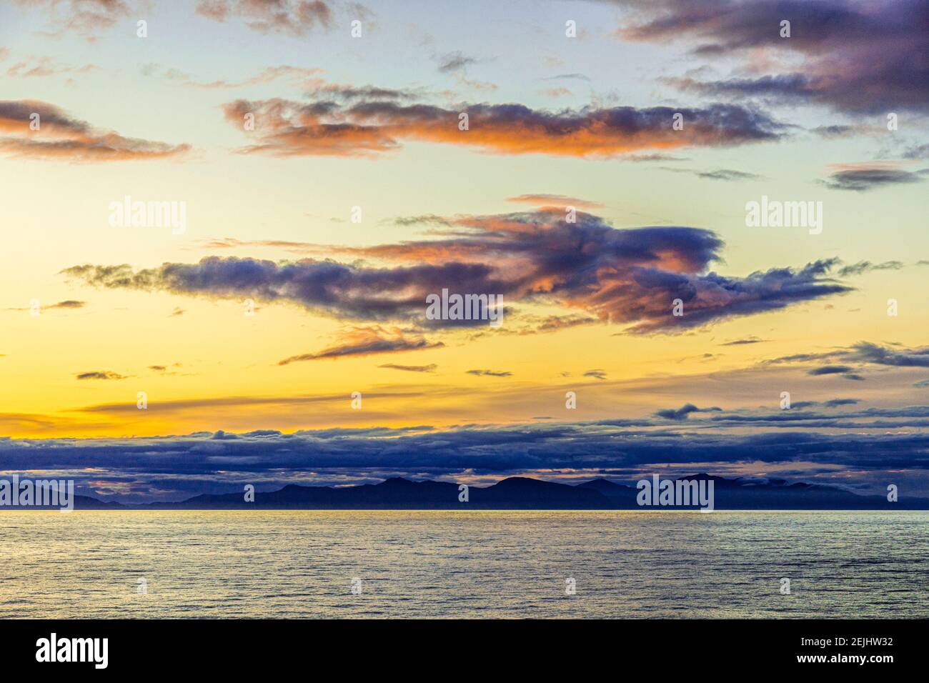 Seltsame Gestalt einer fliegenden Figur oder eines Engels bei Sonnenuntergang über der nordwestlichen Pazifikküste bei Prince of Wales Island, Alaska, USA - von einem Kreuzfahrtschiff aus gesehen. Stockfoto